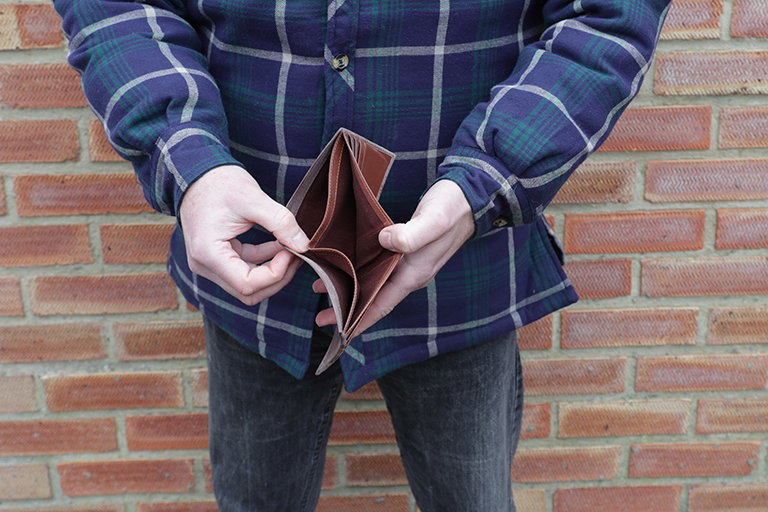 man with no money showing empty wallet