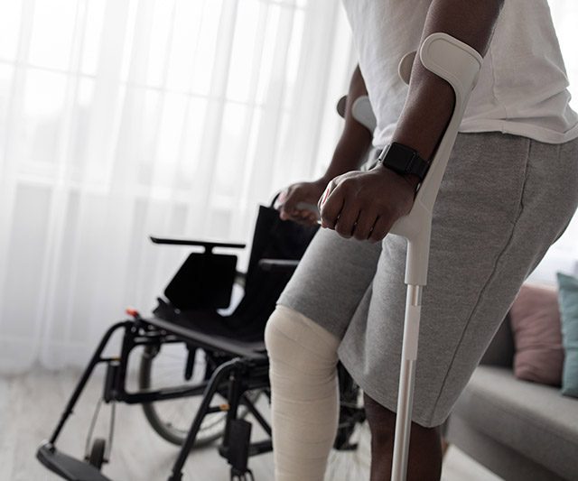 A man with a broken leg using crutches to support himself while walking - Cobb Personal Injury.